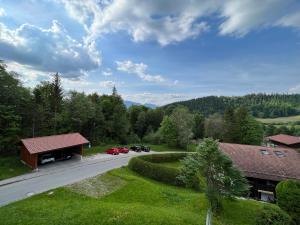 une vue aérienne sur un bâtiment avec des voitures garées sur une route dans l'établissement Bergblick Buchenhöhe, à Berchtesgaden