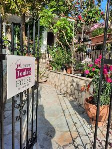 a sign on the gate of a house with flowers at Toulas House in Divarata