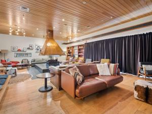 a living room with a brown leather couch and a table at Thredbo Alpine Hotel in Thredbo