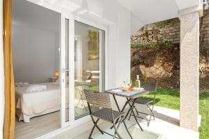 a patio with a table and chairs and a bed at Sardegna è - New Rooms in Olbia