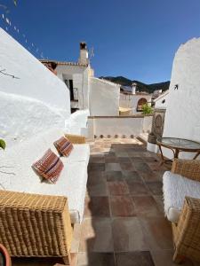 a patio with chairs and tables on a house at Casa Limonero in Sedella