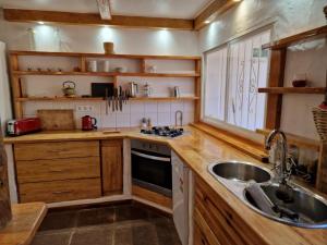 a kitchen with wooden cabinets and a sink and a window at Bolonia Beach Campus in Tarifa