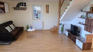 a living room with a couch and a tv at Vineyard cottage Na hribu in Dvor