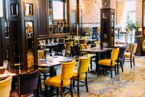 阿馬的住宿－經典英國阿爾馬城市酒店，用餐室配有桌子和黄色椅子