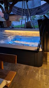 a jacuzzi tub in a patio with a table and chairs at Vineyard cottage Na hribu in Dvor