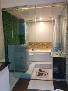 y baño con ducha de cristal y aseo. en Muong Thanh Luxury Condo 5min walk to Thai Consular, en Vientiane