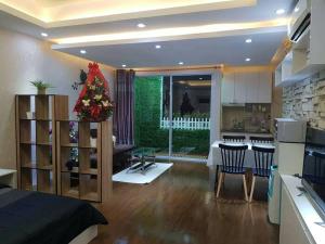 una sala de estar y una cocina con un árbol de Navidad. en Muong Thanh Luxury Condo 5min walk to Thai Consular en Vientián