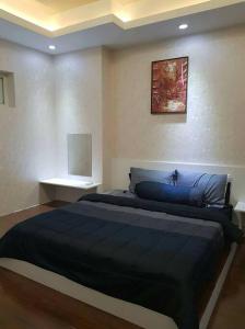 1 dormitorio con 1 cama grande con manta azul en Muong Thanh Luxury Condo 5min walk to Thai Consular en Vientián