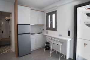 a kitchen with white cabinets and a table and chairs at Agistri Beach in Skala