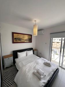 a bedroom with a large bed with towels on it at Seaside Apartments in Paphos City