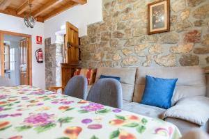 ein Wohnzimmer mit einem Tisch und einer Steinwand in der Unterkunft La Cabada in Ortiguero