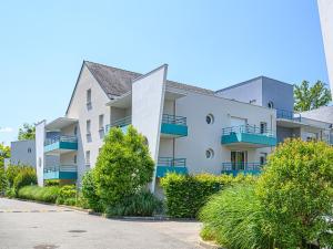 a white apartment building with blue balconies at Vacancéole - Ker Goh Lenn - Vannes / Morbihan in Plescop