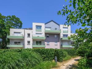 un immeuble avec des buissons verts devant lui dans l'établissement Vacancéole - Ker Goh Lenn - Vannes / Morbihan, à Plescop