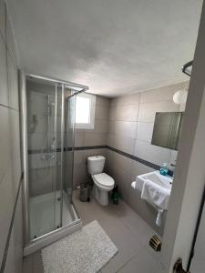a bathroom with a shower and a toilet and a sink at Seaside Apartments in Paphos City