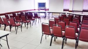 索羅卡巴的住宿－國際廣場酒店，一间教室,配有红色的桌椅和屏幕