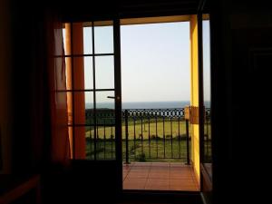 una puerta abierta a un balcón con vistas al océano en APARTAMENTOS EL SOLO en Santillana del Mar