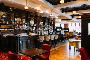 un bar avec de nombreuses tables et chaises dans l'établissement Armagh City Hotel, à Armagh