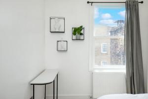 een witte kamer met een bureau en een raam bij Spacious Serenity in the Heart of Central London in Londen