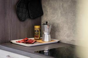 a counter with a plate of bacon and a coffee maker at Deluxe apartman Egle1 i studio Egle 2 in Zagreb