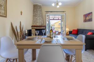 mesa de comedor con sillas blancas y chimenea en Natali Home, en Kanálion