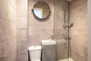 a bathroom with a toilet and a sink and a mirror at Spacious Serenity in the Heart of Central London in London