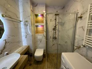 a bathroom with a shower and a toilet and a sink at Moonlight Apart-Hotel Batumi in Batumi +215 photos