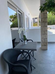 a patio with a table and chairs and windows at Apartments Marin in Podstrana