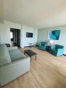 uma sala de estar com 2 sofás e uma televisão de ecrã plano em Ocean Reef Suites em Kill Devil Hills