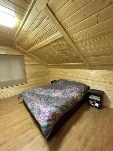 a bedroom with a bed in a wooden room at Pid lisochkom in Verkhovyna