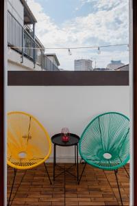 two chairs and a table on a balcony at Attico in Piazza Duomo in Milan