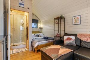 a living room with a couch and a bed in a room at Blaenplwyf Luxury Countryside Shire Pods with Hot Tubs in Lampeter