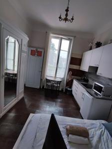 a kitchen with white cabinets and a table at Appartement idéalement situé pour curiste in Châtel-Guyon