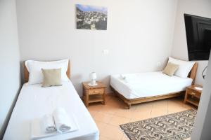 Kleines Zimmer mit 2 Betten und einem TV in der Unterkunft Guesthouse Leo in Berat
