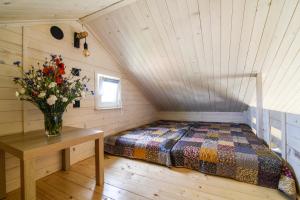 a bedroom with a bed and a vase of flowers on a table at Pogodny domek in Kołczewo