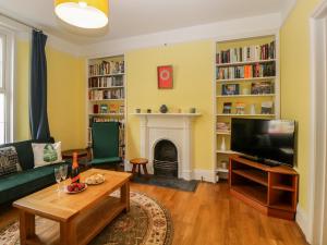 sala de estar con sofá, TV y chimenea en 27 Exeter Street, en Teignmouth