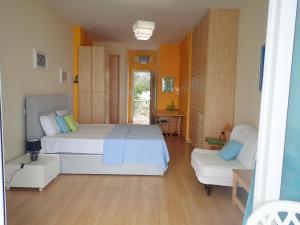 um quarto grande com 2 camas e um sofá em Beachfront Studio with Private Path to the Sea em Poros