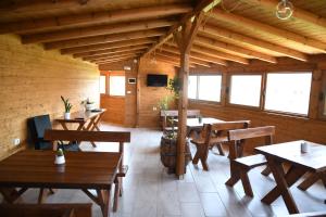 a restaurant with wooden tables and chairs in a room at Guesthouse Leo in Berat