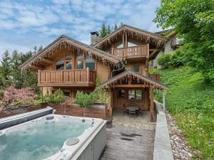 a large wooden house with a hot tub in front of it at Chalet Méribel, 8 pièces, 10 personnes - FR-1-565-65 in Les Allues