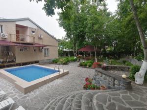 a swimming pool in a yard next to a house at Family Hotel Lago & Wine Cellar in Lagodekhi
