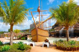 a large wooden boat in a resort with palm trees at Thermas diRoma c entrada Acqua Park in Caldas Novas