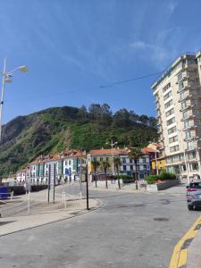 a street with buildings and a mountain in the background at Timón, cerca de la Playa in Candás
