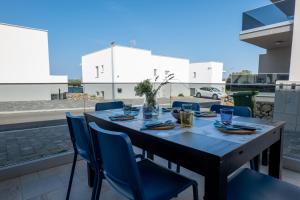 a wooden table with blue chairs on a patio at Casa Carmen Simuni in Šimuni