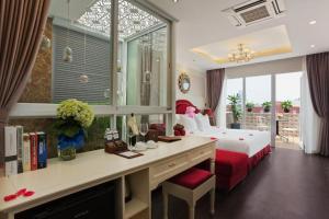 a bedroom with a bed and a desk with a desk at Luxury Old Quarter Hotel & Gym in Hanoi