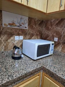 een witte magnetron op een aanrecht in een keuken bij Home Sweet Homes in Rabat