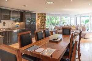 a kitchen and living room with a wooden table and chairs at Trewhiddle Retreat V25 by Together Travel - Luxury 4-Bedroom Villa in St Austell