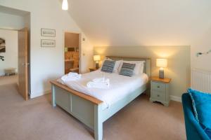 a bedroom with a bed with two towels on it at Trewhiddle Retreat V25 by Together Travel - Luxury 4-Bedroom Villa in St Austell