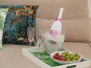 un vassoio con una bottiglia di champagne e una ciotola di uva di Arena Castelldefels a Castelldefels