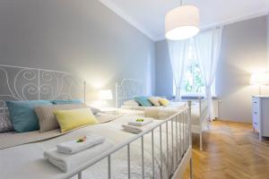 a baby bedroom with two beds and a crib at Tyzenhauz Grand Apartaments in Kraków