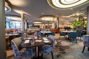 a restaurant with tables and chairs in a room at Van der Valk Hotel Breda in Breda