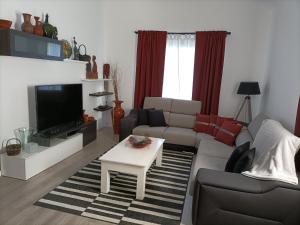 sala de estar con sofá y TV en Sons da Ribeira, en Povoação
